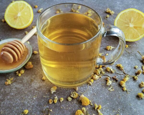 A cup of herbal tea with lemon and honey